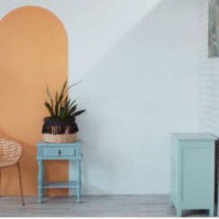 Arco na parede destacado numa sala com decoração e um armário